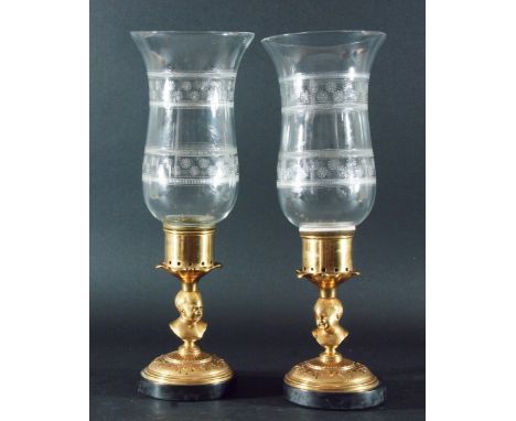 PAIR OF BRASS STORM LANTERNS, the waisted and engraved glass shades on bases with child bust columns, the circular foot with 
