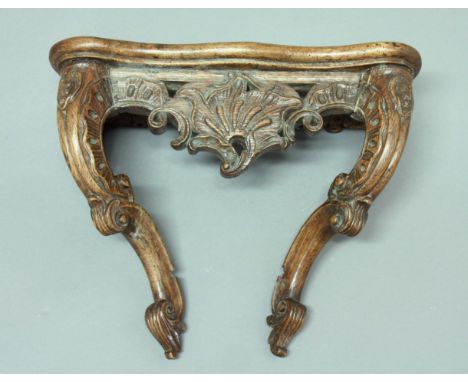 FRENCH WALNUT WALL BRACKET, possibly 18th century, in the form of a serpentine console table with scrolling legs, height 29cm