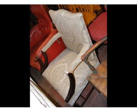 An armchair upholstered in light green floral material 