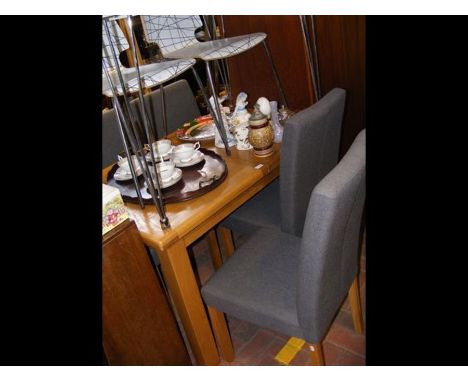 A light oak extending dining table together with the set of four dining chairs - upholstered in grey