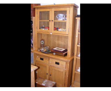 A light oak side cabinet with glazed upper section, two drawers and cupboards under - width 110cms