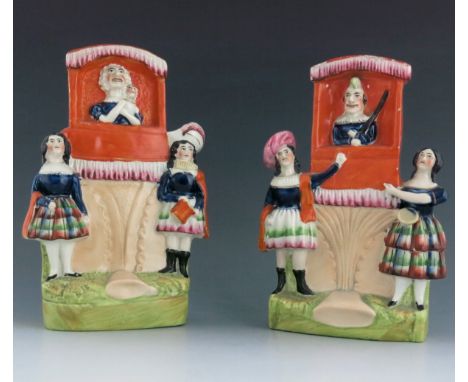 A pair of Staffordshire puppet show figure groups of Punch and Judy, circa , each modelled in orange painted tents flanked by