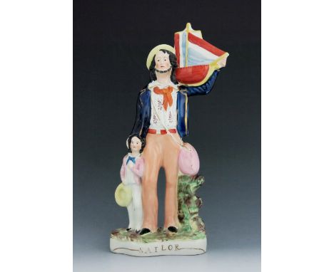 A Staffordshire figure of a ‘Sailor’, circa 1855, modelled standing with a boy to his right, holding a ship and wearing a blu