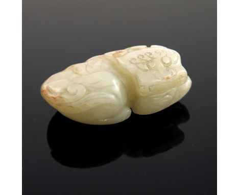 A Chinese pale jade netsuke, in the form of a recumbent stylized shishi, 5.5cm wide