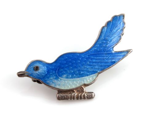 A silver and enamelled brooch, in the form of a bluebird, basse taille variegated enamel, modelled standing on a branch, 3.5c