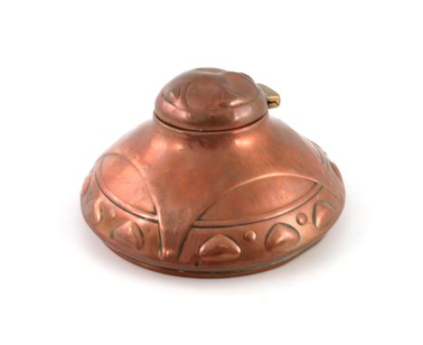 A Jugendstil copper and brass inkwell, squat ogee domed form, embossed with strapped arcading and band of triangular lozenges