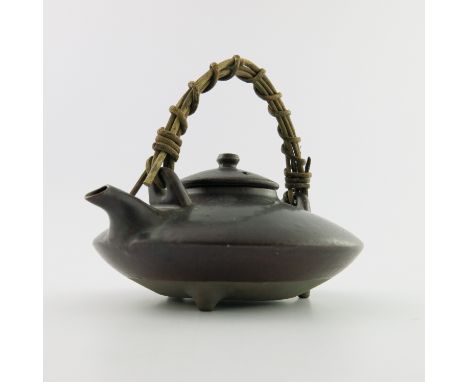 A Japanese ceramic sake kettle, cane handle, marks to base, 14cm high including handle