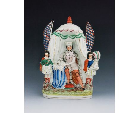 A Staffordshire figure of King John signing the Magna Carta, circa 1860, modelled seated, sheltered by a royal tent flanked b