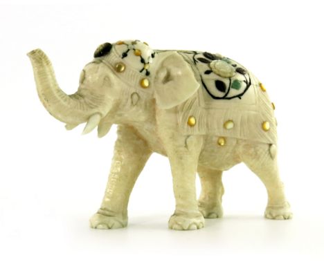 λ A Japanese ivory Shibayama model of an elephant, Meiji period, wearing a saddle strolling with trunk up, 5.5cm high