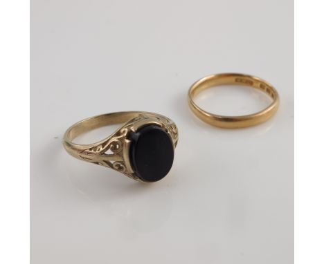 A 22ct yellow gold wedding band, 2.5gms;  together with a 9ct gold black oval gem set ring with reticulated scroll work shoul