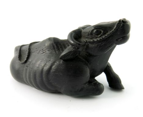A Chinese hardwood treen netsuke, in the form of a recumbent water buffalo, signed, 8.5cm wide