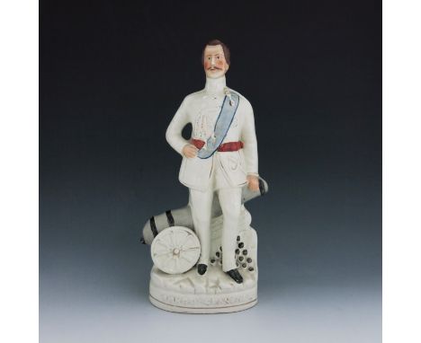 A Staffordshire figure of the 'Duke of Clarence', circa 1891, modelled standing beside a cannon, his left hand resting on the