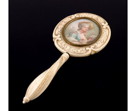 λ An ivory miniature hand mirror, 19th Century, possibly Dieppe, wrythen turned handle, scroll border oval frame with an inse