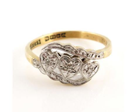 An 18ct gold diamond set ring, the split band united with three heart shaped motifs with illusion set single cut diamonds, 1.