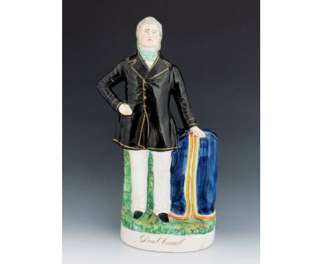 A Staffordshire figure of 'Dan O'Connell', circa 1875, modelled standing beside a draped pedestal, wearing a black coat with 