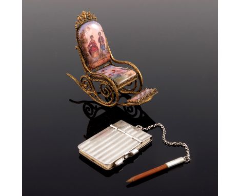 A Continental gilt miniature rocking chair, the seat back, seat and footrest with figure and landscape scenes in pink guilloc