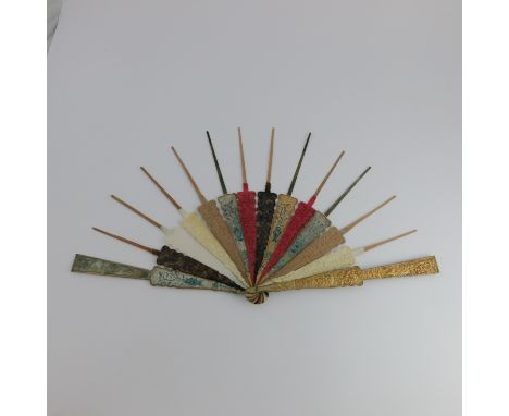 λ A Chinese Qing dynasty mandarin fan frame, with relief cast gilt-metal guards, the sticks alternating in carved and coloure