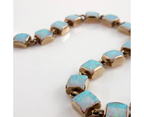 A 9ct gold and opal set bracelet, sixteen square cut opals in double link square collared gold setting, stamped 375, 18.5cm l