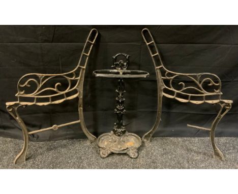 A Victorian style cast iron stick stand, 55cm high, 28cm wide;  pair of cast iron scrollwork garden bench ends (3) 