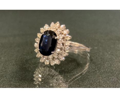 A sapphire and diamond ring, central oval blue sapphire 9mm x 6.7mm x 2.9mm, calculated sapphire weight, 1.40ct, surrounded b