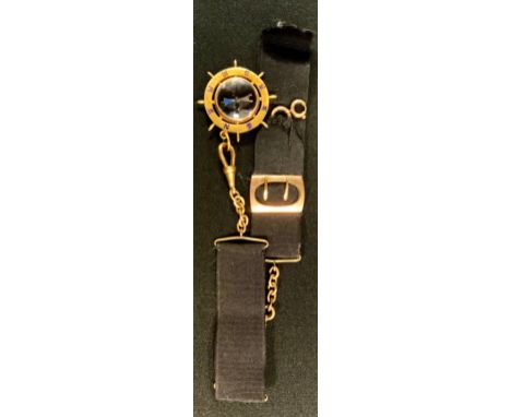 An early 20th century gold plated Ships Wheel compass fob medal, enamelled to the eight principal points on both sides, point