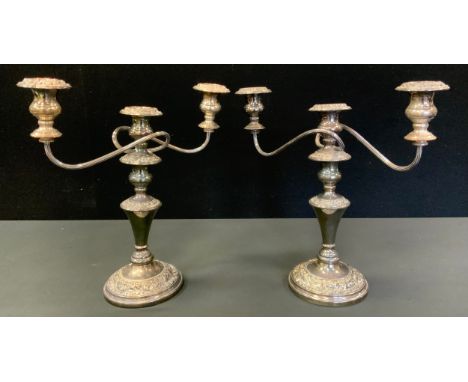 A pair of plated three light two branch candelabra, cast with foliate scrolls, 35cm high 