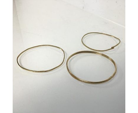 A 9ct gold textured stiff bangle (repairs) and two other 9ct gold textured bangles (one a/f) (combined: 12.65g)