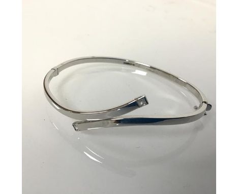 A 9ct white gold stiff hinged bangle, set with two clear stones (6.5cm x 5.5cm) (5.65g)