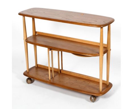 An Ercol  beech and elm divider bookcase, two tiers, on rollers, with retractable tray and spindle divider to lower part, the