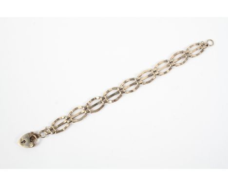 A yellow metal three bar gate bracelet with padlock and safety chain. Hallmarked 9ct gold, London, 1975 7.3 grams