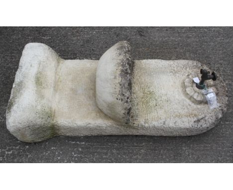 A cast stone tap feature, a bronze effect tap pouring into a crescent shaped bowl on an arching panel, height 125cm x width 5