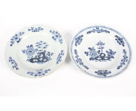 A near pair of English delftware blue and white chargers, circa 1760, London or Bristol, painted with chinoiserie shrubs and 