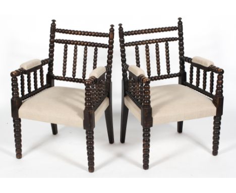 A pair of bobbin turned armchairs, late 19th century, each ebonised and upholstered in cream linen, 87 cm high (2)