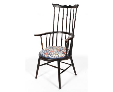 An Arts and Crafts style ebonised comb back windsor chair, with William Morris style upholstered cushion, 113cm high