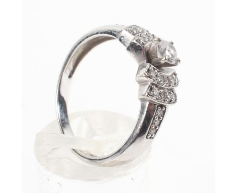 A white metal ring principally set with a round brilliant cut diamond estimated to weigh 0.25cts. Finished with stepped diamo