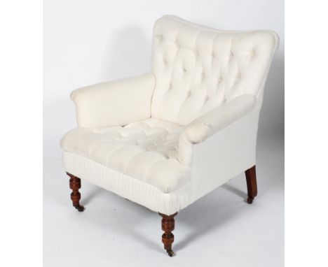 A Victorian button back armchair, with scrolled arms, on turned front legs and casters, 85cm high