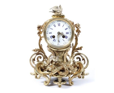 A French gilt metal mantel clock, the 3 3/4" enamelled dial on a brass, eight day movement striking to a bell, the case with 