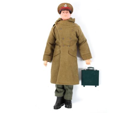 An Action man, with moulded brown hair, wearing a green great coat, jumper, trousers, black boots and a cap