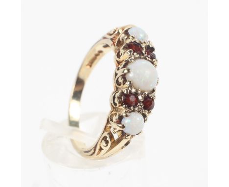 A yellow metal half hoop ring set with graduated round cabochon opals, interspaced with garnet pairs. Hallmarked 9ct gold, Lo