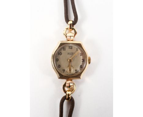 A yellow gold Tissot mechanical watch. Circular champagne dial with numerical markings and seconds dial. Fitted brown leather