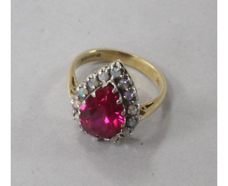 An 18ct gold, pear shaped synthetic ruby and white opal cluster dress ring, size L.