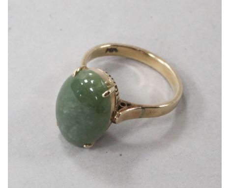 A 14ct gold and oval cabochon jade ring, size L.