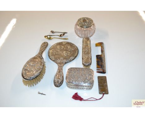 A silver backed dressing table mirror with cherub decoration, matching brushes and comb; a similar silver mounted glass tidy 