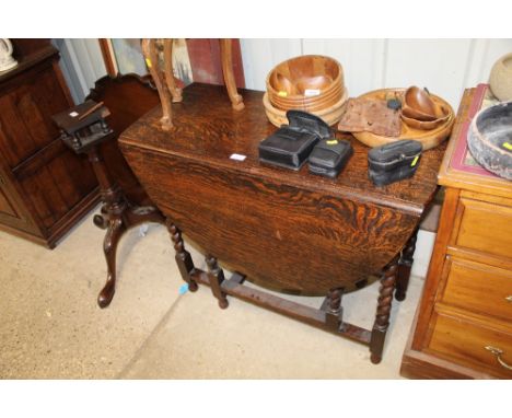 A 19th Century oak gate leg table raised on barleytwist supports 