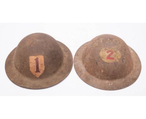 A WWII MK I steel helmet  marked 'Stage 2': together with one other with a red '1' on a white shield, also inscribed to under