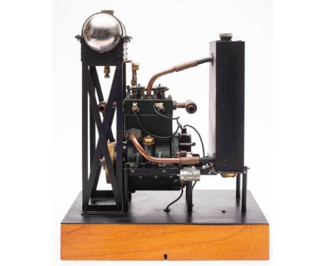 A scale model of a twin piston four stroke engine,  3 inch brass flywheel, green painted rocker cover and block with steel ro