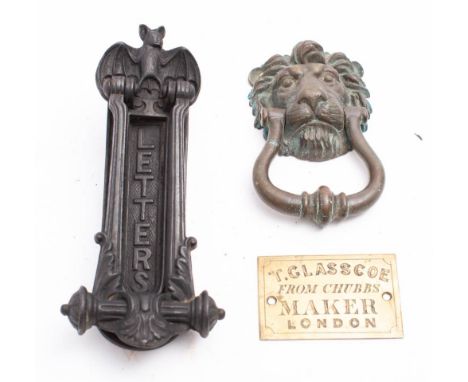 A brass lion's mask door knocker:, 17cm high and a cast iron door knocker letter box by A Kenrick &amp; Sons with winged bat 