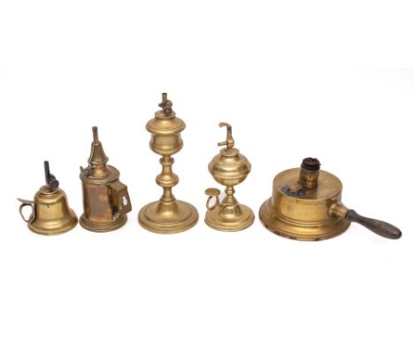 A brass hand held oil lamp: of bell shape, two other brass hand held lamps, a brass candlestick oil lamp and one other with t