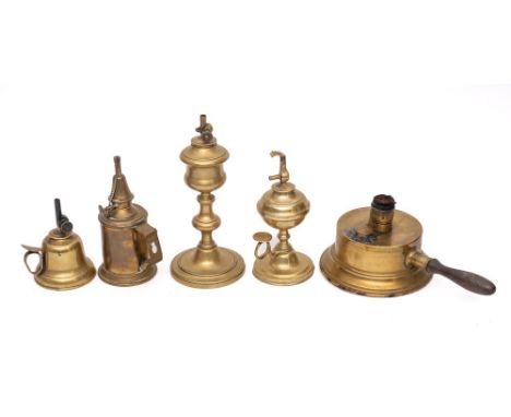 A brass hand held oil lamp: of bell shape, two other brass hand held lamps, a brass candlestick oil lamp and one other with t