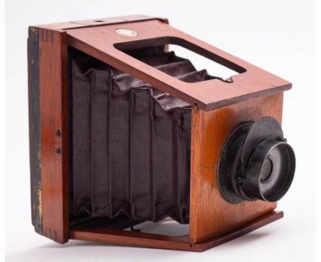 A mahogany and brass 'The XIT' three quarter plate strut camera by Shew, London; with brass lens stamped 'F11', dark burgundy